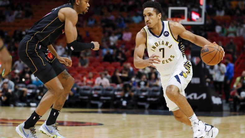 Dec 21, 2021; Miami, Florida, USA; Indiana Pacers guard Malcolm Brogdon (7) dribbles the basketball against Miami Heat forward KZ Okpala (11) during the first half at FTX Arena. Mandatory Credit: Sam Navarro-USA TODAY Sports