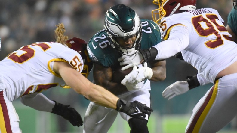 Dec 21, 2021; Philadelphia, Pennsylvania, USA; Philadelphia Eagles running back Miles Sanders (26) his tackled by Washington Football Team outside linebacker Cole Holcomb (55) and defensive end Casey Toohill (95) during the second quarter at Lincoln Financial Field. Mandatory Credit: Eric Hartline-USA TODAY Sports