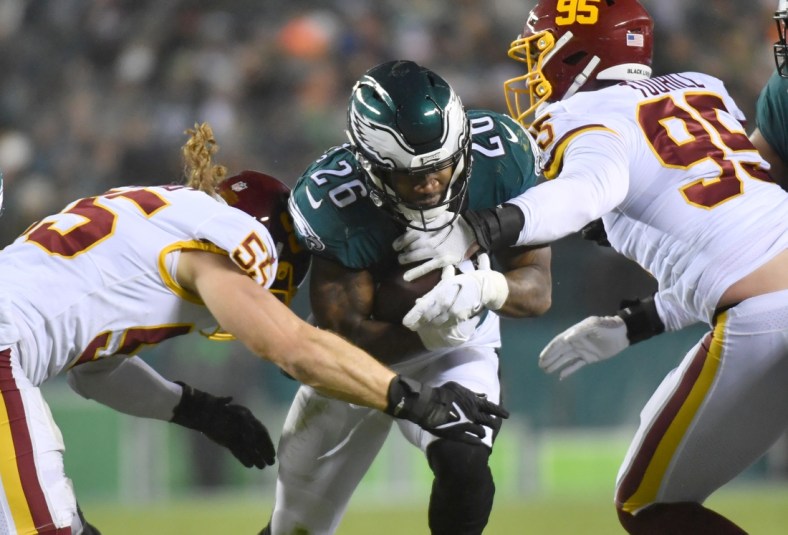 Dec 21, 2021; Philadelphia, Pennsylvania, USA; Philadelphia Eagles running back Miles Sanders (26) his tackled by Washington Football Team outside linebacker Cole Holcomb (55) and defensive end Casey Toohill (95) during the second quarter at Lincoln Financial Field. Mandatory Credit: Eric Hartline-USA TODAY Sports