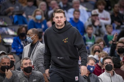 Dec 21, 2021; Dallas, Texas, USA; Dallas Mavericks guard Luka Doncic (77) watches from the team bench during the first quarter of the game between the Dallas Mavericks and the Minnesota Timberwolves at the American Airlines Center. Mandatory Credit: Jerome Miron-USA TODAY Sports