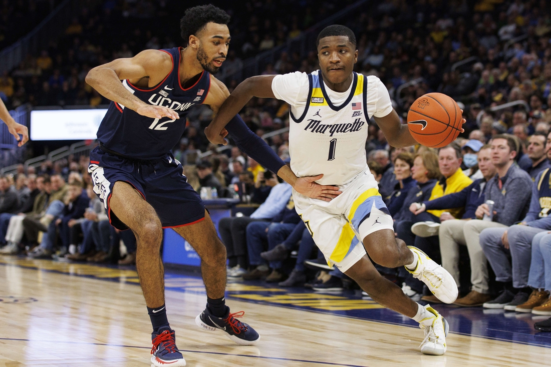 Dec 21, 2021; Milwaukee, Wisconsin, USA;  Marquette Golden Eagles guard Kam Jones (1) drives to the basket against Connecticut Huskies forward Tyler Polley (12) during the first half at Fiserv Forum. Mandatory Credit: Jeff Hanisch-USA TODAY Sports