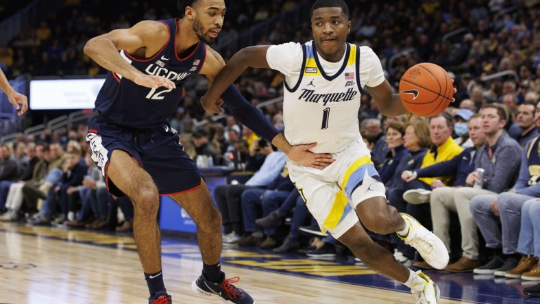 Dec 21, 2021; Milwaukee, Wisconsin, USA;  Marquette Golden Eagles guard Kam Jones (1) drives to the basket against Connecticut Huskies forward Tyler Polley (12) during the first half at Fiserv Forum. Mandatory Credit: Jeff Hanisch-USA TODAY Sports