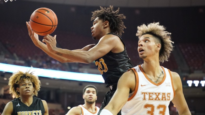 Dec 22, 2021; Austin, Texas, USA; Alabama State Hornets guard Kenny Strawbridge (20) grabs a rebound over Texas Longhorns forward Tre Mitchell (33) during the first half at Frank C. Erwin Jr. Center. Mandatory Credit: Scott Wachter-USA TODAY Sports