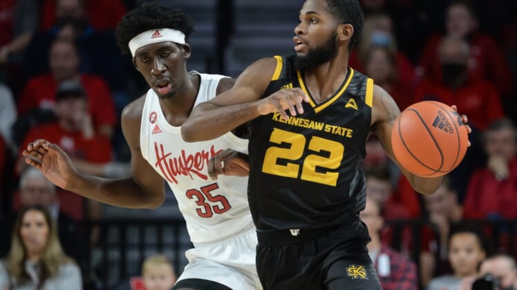 Dec 22, 2021; Lincoln, Nebraska, USA; Kennesaw State Owls guard Spencer Rodgers (22) dribbles around Nebraska Cornhuskers center Eduardo Andre (35) in the first half at Pinnacle Bank Arena. Mandatory Credit: Steven Branscombe-USA TODAY Sports