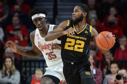 Dec 22, 2021; Lincoln, Nebraska, USA; Kennesaw State Owls guard Spencer Rodgers (22) dribbles around Nebraska Cornhuskers center Eduardo Andre (35) in the first half at Pinnacle Bank Arena. Mandatory Credit: Steven Branscombe-USA TODAY Sports