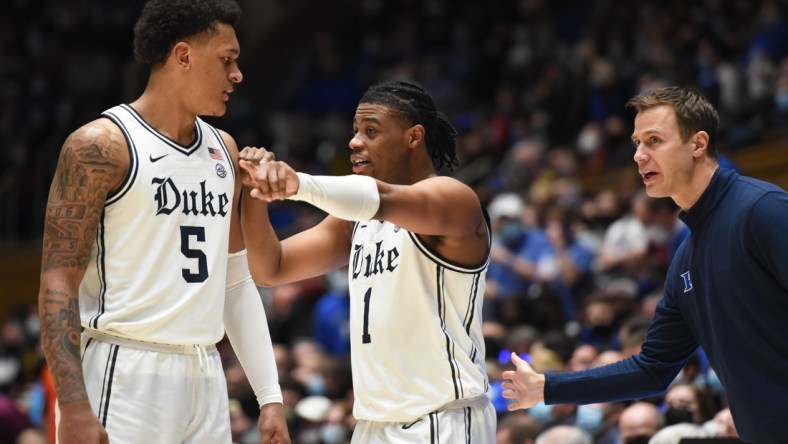 Dec 22, 2021; Durham, North Carolina, USA; Duke Blue Devils forward Paolo Banchero (5) talks with guard Trevor Keels (1) and associate head coach Jon Scheyer (right) during the second half against the Virginia Tech Hokies at Cameron Indoor Stadium.  The Blue Devils won 76-65. Mandatory Credit: Rob Kinnan-USA TODAY Sports