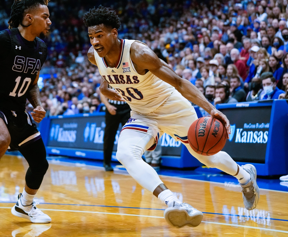 Dec 18, 2021; Lawrence, Kansas, USA; Kansas Jayhawks guard Ochai Agbaji (30) drives against Stephen F. Austin Lumberjacks guard Latrell Jossell (10) during the second half at Allen Fieldhouse. Mandatory Credit: Jay Biggerstaff-USA TODAY Sports