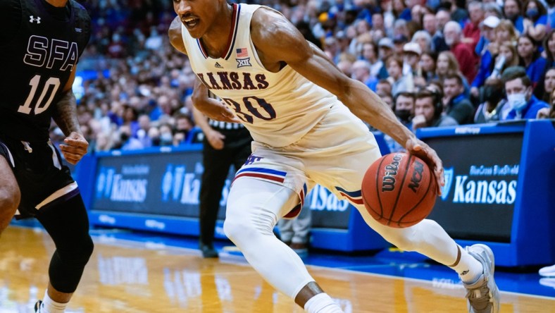 Dec 18, 2021; Lawrence, Kansas, USA; Kansas Jayhawks guard Ochai Agbaji (30) drives against Stephen F. Austin Lumberjacks guard Latrell Jossell (10) during the second half at Allen Fieldhouse. Mandatory Credit: Jay Biggerstaff-USA TODAY Sports