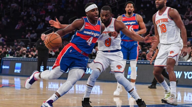 Dec 23, 2021; New York, New York, USA; Washington Wizards guard Aaron Holiday (4) dribbles the ball past New York Knicks guard Kemba Walker (8) during the first quarter at Madison Square Garden. Mandatory Credit: Dennis Schneidler-USA TODAY Sports