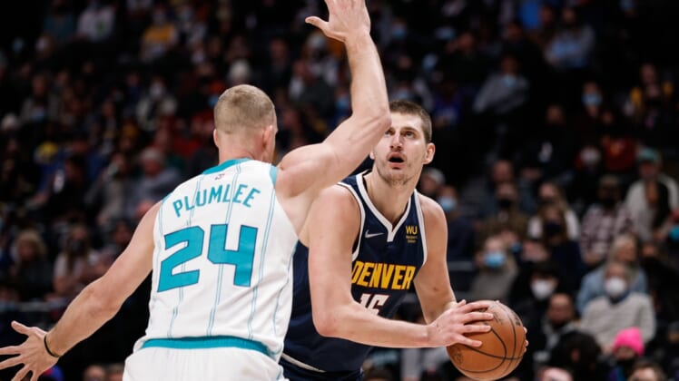Dec 23, 2021; Denver, Colorado, USA; Denver Nuggets center Nikola Jokic (15) controls the ball as Charlotte Hornets center Mason Plumlee (24) guards in the first quarter at Ball Arena. Mandatory Credit: Isaiah J. Downing-USA TODAY Sports