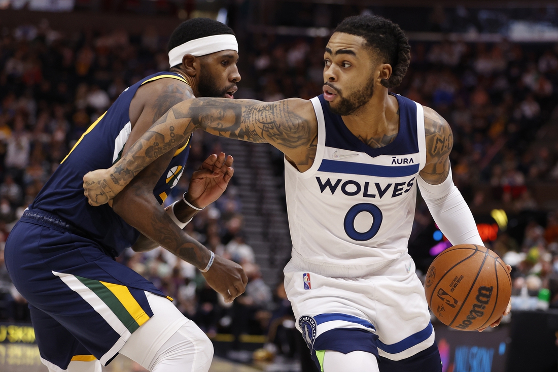 Dec 23, 2021; Salt Lake City, Utah, USA; Minnesota Timberwolves guard D'Angelo Russell (0) drives against Utah Jazz forward Royce O'Neale (23) in the first quarter at Vivint Arena. Mandatory Credit: Jeffrey Swinger-USA TODAY Sports