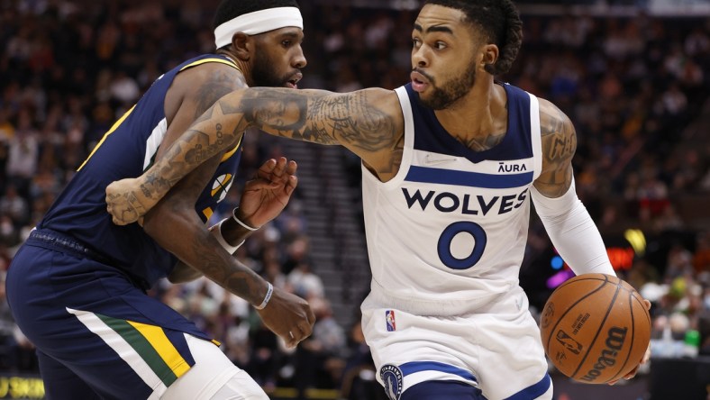 Dec 23, 2021; Salt Lake City, Utah, USA; Minnesota Timberwolves guard D'Angelo Russell (0) drives against Utah Jazz forward Royce O'Neale (23) in the first quarter at Vivint Arena. Mandatory Credit: Jeffrey Swinger-USA TODAY Sports