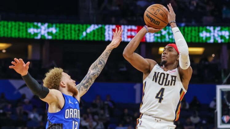 Dec 23, 2021; Orlando, Florida, USA; New Orleans Pelicans guard Devonte' Graham (4) shoots the ball against Orlando Magic guard Hassani Gravett (12) during the second half at Amway Center. Mandatory Credit: Mike Watters-USA TODAY Sports