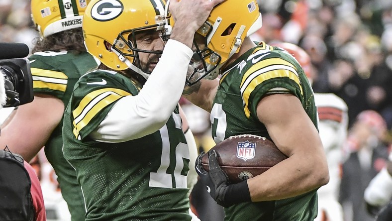 Dec 25, 2021; Green Bay, Wisconsin, USA; Green Bay Packers quarterback Aaron Rodgers (12) celebrates with wide receiver Allen Lazard (13) after setting the franchise record for most passing TDs in the first quarter during the game against the Cleveland Browns at Lambeau Field. Mandatory Credit: Benny Sieu-USA TODAY Sports