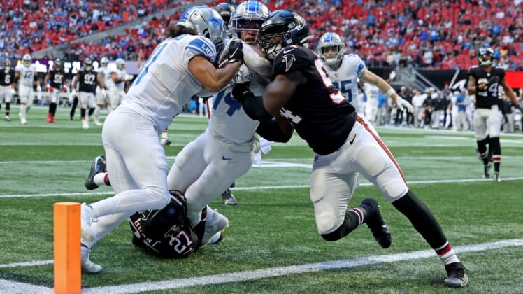 Dec 26, 2021; Atlanta, Georgia, USA; Detroit Lions wide receiver Amon-Ra St. Brown (14) scores a touchdown after making a catch against Atlanta Falcons safety Richie Grant (27) and inside linebacker Foye Oluokun (54) as Detroit Lions wide receiver Kalif Raymond (11) helps during the second quarter at Mercedes-Benz Stadium. Mandatory Credit: Jason Getz-USA TODAY Sports