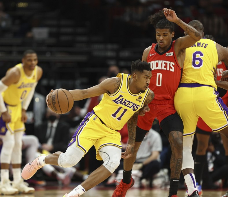 Dec 28, 2021; Houston, Texas, USA; Los Angeles Lakers guard Malik Monk (11) attempts to dribble the ball around Houston Rockets guard Jalen Green (0) during the first quarter at Toyota Center. Mandatory Credit: Troy Taormina-USA TODAY Sports