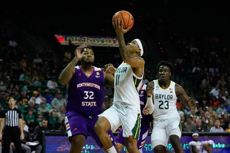 Dec 28, 2021; Waco, Texas, USA;  Baylor Bears guard James Akinjo (11) drives to the basket against Northwestern State Demons center Larry Owens (32) during the second half at Ferrell Center. Mandatory Credit: Chris Jones-USA TODAY Sports