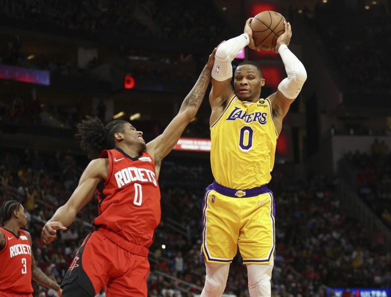 Dec 28, 2021; Houston, Texas, USA; Los Angeles Lakers guard Russell Westbrook (0) grabs a rebound away from Houston Rockets guard Jalen Green (0) during the fourth quarter at Toyota Center. Mandatory Credit: Troy Taormina-USA TODAY Sports
