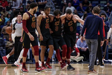 Dec 28, 2021; New Orleans, Louisiana, USA; Cleveland Cavaliers guard Ricky Rubio (3) is helped off the court by forward Kevin Love (0) and forward Isaac Okoro (35) after injuring his ankle against New Orleans Pelicans forward Herbert Jones (5) during the second half at Smoothie King Center. Mandatory Credit: Stephen Lew-USA TODAY Sports