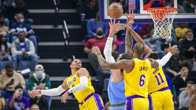 Dec 29, 2021; Memphis, Tennessee, USA; Los Angeles Lakers guard Russell Westbrook (0) and forward LeBron James (6) and guard Malik Monk (11) fight for the rebound with Memphis Grizzlies center Steven Adams (4) during the first quarter at the FedExForum. Mandatory Credit: Jerome Miron-USA TODAY Sports