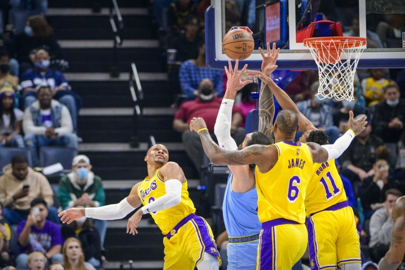 Dec 29, 2021; Memphis, Tennessee, USA; Los Angeles Lakers guard Russell Westbrook (0) and forward LeBron James (6) and guard Malik Monk (11) fight for the rebound with Memphis Grizzlies center Steven Adams (4) during the first quarter at the FedExForum. Mandatory Credit: Jerome Miron-USA TODAY Sports