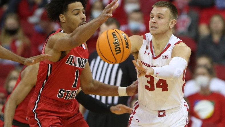 Dec 29, 2021; Madison, Wisconsin, USA; Wisconsin Badgers guard Brad Davison (34) passes the ball as Illinois State Redbirds forward Sy Chatman (1) defends during the first half at the Kohl Center. Mandatory Credit: Mary Langenfeld-USA TODAY Sports