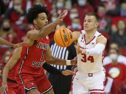 Dec 29, 2021; Madison, Wisconsin, USA; Wisconsin Badgers guard Brad Davison (34) passes the ball as Illinois State Redbirds forward Sy Chatman (1) defends during the first half at the Kohl Center. Mandatory Credit: Mary Langenfeld-USA TODAY Sports