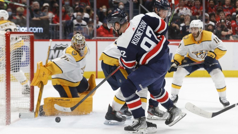 Dec 29, 2021; Washington, District of Columbia, USA; Washington Capitals center Evgeny Kuznetsov (92) shoots the puck on Nashville Predators goaltender Juuse Saros (74) during the third period at Capital One Arena. Mandatory Credit: Geoff Burke-USA TODAY Sports