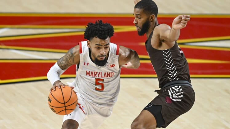 Dec 30, 2021; College Park, Maryland, USA;  Maryland Terrapins guard Eric Ayala (5) dribbles as Brown Bears guard David Mitchell (0) defends during  the first half at Xfinity Center. Mandatory Credit: Tommy Gilligan-USA TODAY Sports