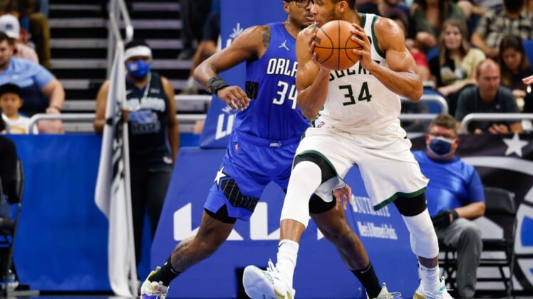 Dec 30, 2021; Orlando, Florida, USA; Milwaukee Bucks forward Giannis Antetokounmpo (34) drives the ball past Orlando Magic center Wendell Carter Jr. (34) in the second quarter at Amway Center. Mandatory Credit: Nathan Ray Seebeck-USA TODAY Sports