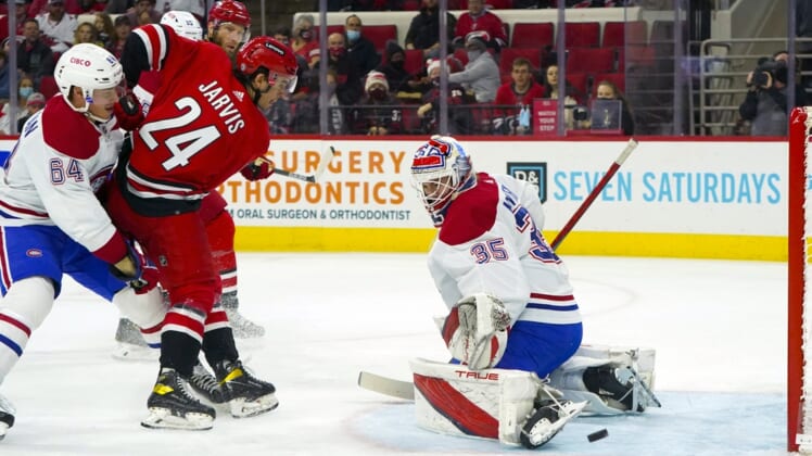Dec 30, 2021; Raleigh, North Carolina, USA;  Montreal Canadiens goaltender Sam Montembeault (35) turns the shot away from Carolina Hurricanes center Seth Jarvis (24) during the first period at PNC Arena. Mandatory Credit: James Guillory-USA TODAY Sports