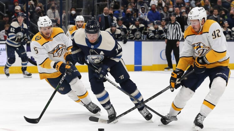 Dec 30, 2021; Columbus, Ohio, USA; Nashville Predators center Ryan Johansen (92) takes the puck off the stick of Columbus Blue Jackets center Gustav Nyquist (14) during the second period at Nationwide Arena. Mandatory Credit: Russell LaBounty-USA TODAY Sports