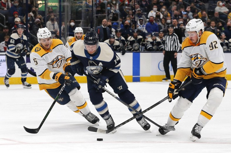 Dec 30, 2021; Columbus, Ohio, USA; Nashville Predators center Ryan Johansen (92) takes the puck off the stick of Columbus Blue Jackets center Gustav Nyquist (14) during the second period at Nationwide Arena. Mandatory Credit: Russell LaBounty-USA TODAY Sports