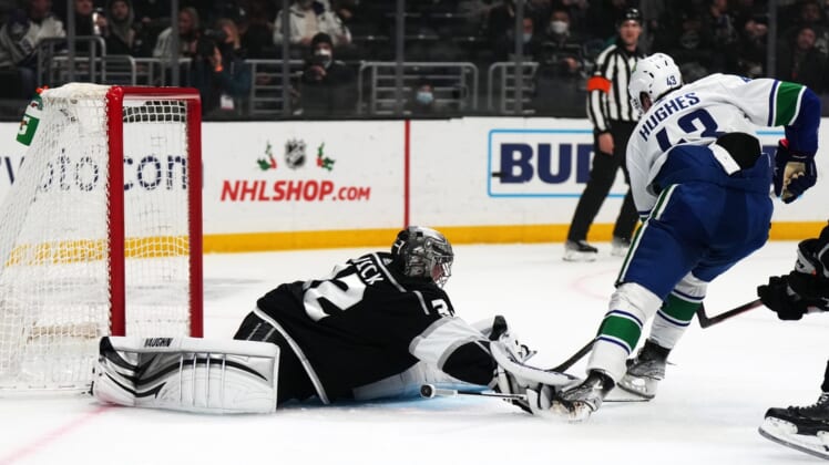Dec 30, 2021; Los Angeles, California, USA; LA Kings goaltender Jonathan Quick (32) defends the goal against Vancouver Canucks defenseman Quinn Hughes (43) in the first period at Crypto.com Arena. Mandatory Credit: Kirby Lee-USA TODAY Sports