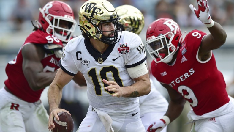 Wake Forest Demon Deacons quarterback Sam Hartman (10) is pressured in the pocket during the second quarter Friday, Dec. 31, 2021 at TIAA Bank Field in Jacksonville. The Wake Forest Demon Deacons and the Rutgers Scarlet Knights faced each other in the 2021 TaxSlayer Gator Bowl. [Corey Perrine/Florida Times-Union]