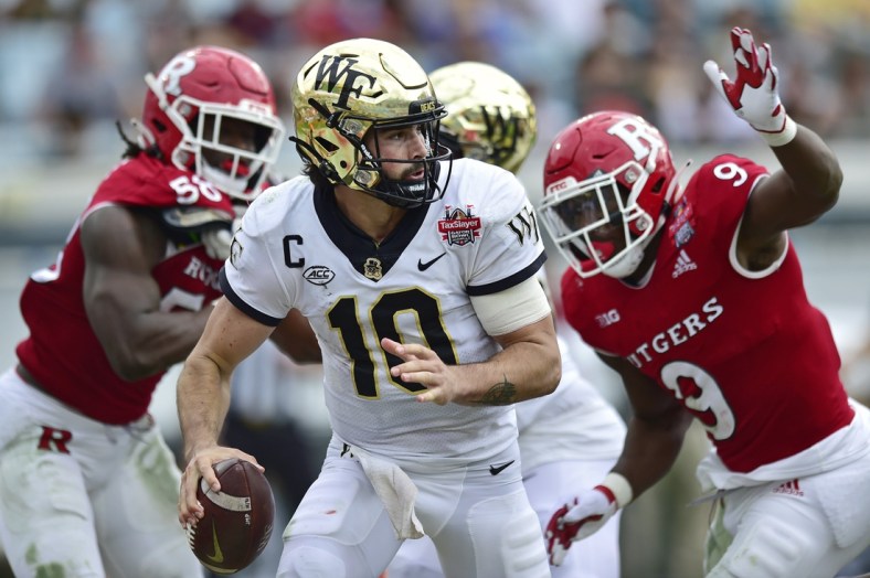 Wake Forest Demon Deacons quarterback Sam Hartman (10) is pressured in the pocket during the second quarter Friday, Dec. 31, 2021 at TIAA Bank Field in Jacksonville. The Wake Forest Demon Deacons and the Rutgers Scarlet Knights faced each other in the 2021 TaxSlayer Gator Bowl. [Corey Perrine/Florida Times-Union]