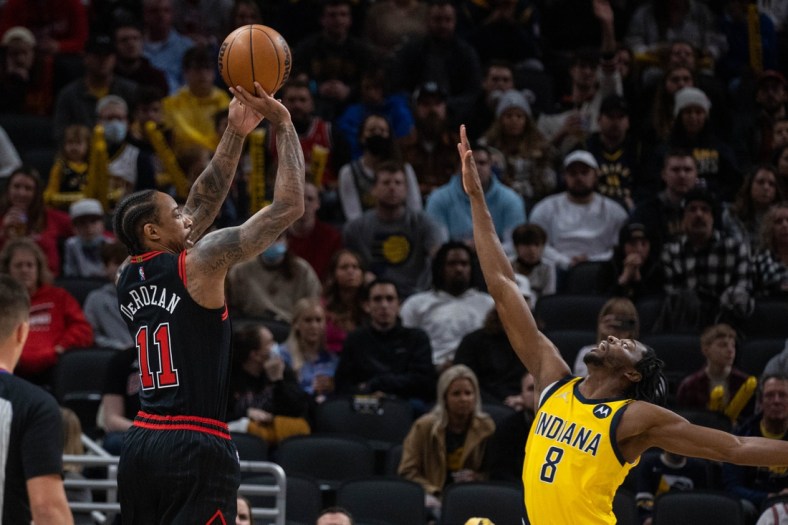 Dec 31, 2021; Indianapolis, Indiana, USA; Chicago Bulls forward DeMar DeRozan (11) shoots the ball while Indiana Pacers forward Justin Holiday (8) defends in the first quarter at Gainbridge Fieldhouse. Mandatory Credit: Trevor Ruszkowski-USA TODAY Sports