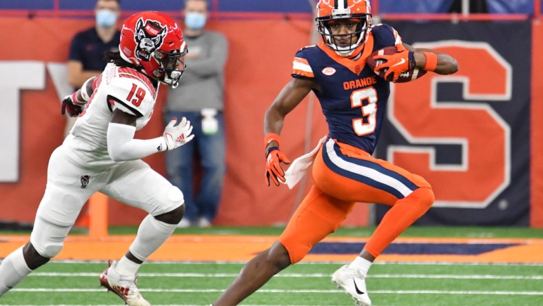 Nov 28, 2020; Syracuse, New York, USA; Syracuse Orange wide receiver Taj Harris (3) runs from North Carolina State Wolfpack defensive back Joshua Pierre-Louis (19) after making a catch in the second quarter at the Carrier Dome. Mandatory Credit: Mark Konezny-USA TODAY Sports