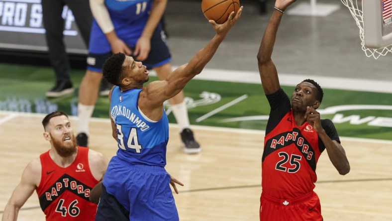 Feb 18, 2021; Milwaukee, Wisconsin, USA;  Milwaukee Bucks forward Giannis Antetokounmpo (34) shoots against Toronto Raptors forward Chris Boucher (25) during the second quarter at Fiserv Forum. Mandatory Credit: Jeff Hanisch-USA TODAY Sports