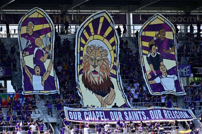 Apr 17, 2021; Orlando, Florida, USA; General view of the Orlando City SC supporters stands raising a sign prior to the game against the Atlanta United FC at Orlando City Stadium. Mandatory Credit: Douglas DeFelice-USA TODAY Sports