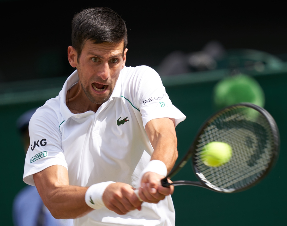 Jul 11, 2021; London, United Kingdom; Novak Djokovic (SRB) hits the ball against Matteo Berrettini (ITA) in the men s final  on Centre Court at All England Lawn Tennis and Croquet Club. Mandatory Credit: Peter van den Berg-USA TODAY Sports