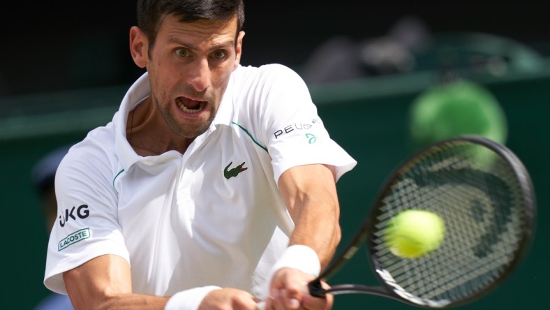 Jul 11, 2021; London, United Kingdom; Novak Djokovic (SRB) hits the ball against Matteo Berrettini (ITA) in the men s final  on Centre Court at All England Lawn Tennis and Croquet Club. Mandatory Credit: Peter van den Berg-USA TODAY Sports