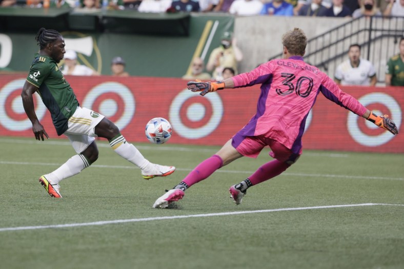 Aug 15, 2021; Portland, Oregon, USA; Seattle Sounders FC goalkeeper Stefan Cleveland (30) stretches to stop the ball kicked by Portland Timbers midfielder Yimmi Chara (23) during the first half at Providence Park. Mandatory Credit: Soobum Im-USA TODAY Sports