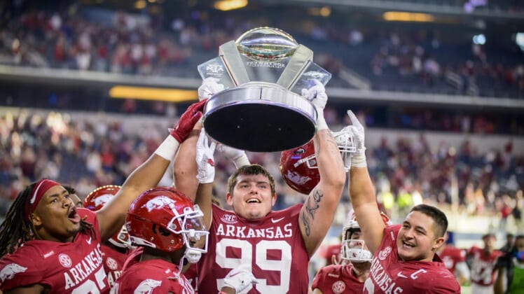 Sep 25, 2021; Arlington, Texas, USA;  Arkansas Razorbacks defensive lineman Eric Thomas Jr. (37) and defensive lineman John Ridgeway (99) and linebacker Grant Morgan (31) hold up the Southwest Classic trophy as they celebrate the win over the Texas A&M Aggies at AT&T Stadium. Mandatory Credit: Jerome Miron-USA TODAY Sports