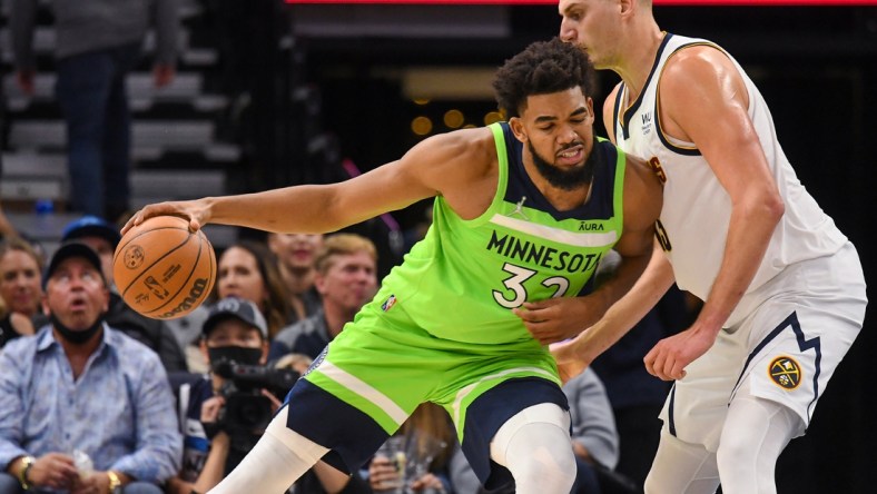 Oct 30, 2021; Minneapolis, Minnesota, USA;  Minnesota Timberwolves center Karl-Anthony Towns (32) is called for an offensive foul against Denver Nuggets center Nikola Jokic (15) during the second quarter at Target Center. Mandatory Credit: Nick Wosika-USA TODAY Sports