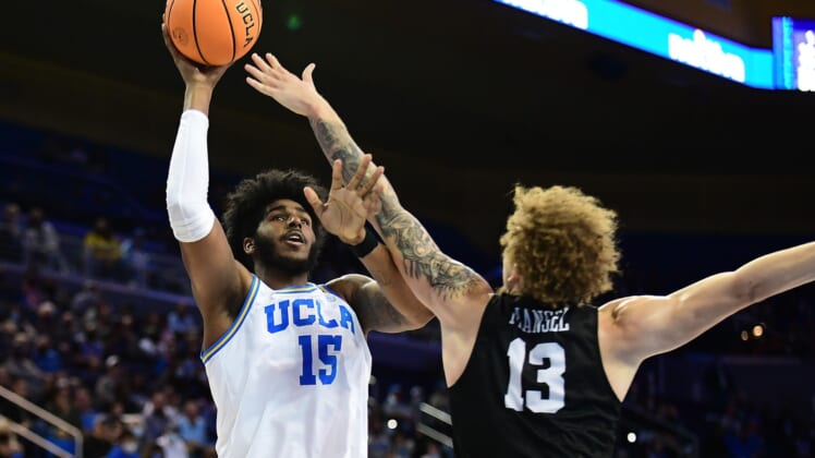 Nov 15, 2021; Los Angeles, California, USA; UCLA Bruins center Myles Johnson (15) shoots against Long Beach State 49ers forward Romelle Mansel (13) during the second half at Pauley Pavilion. Mandatory Credit: Gary A. Vasquez-USA TODAY Sports