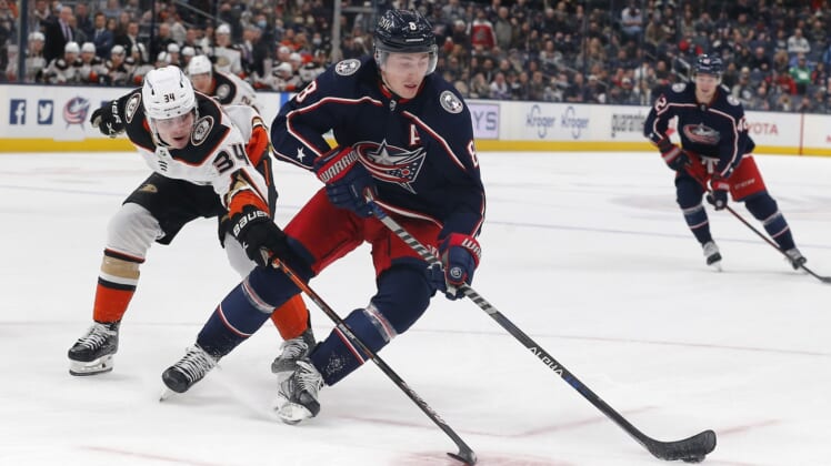 Dec 9, 2021; Columbus, Ohio, USA; Columbus Blue Jackets defenseman Zach Werenski (8) skates away from the check of Anaheim Ducks defenseman Jamie Drysdale (34) during overtime at Nationwide Arena. Mandatory Credit: Russell LaBounty-USA TODAY Sports