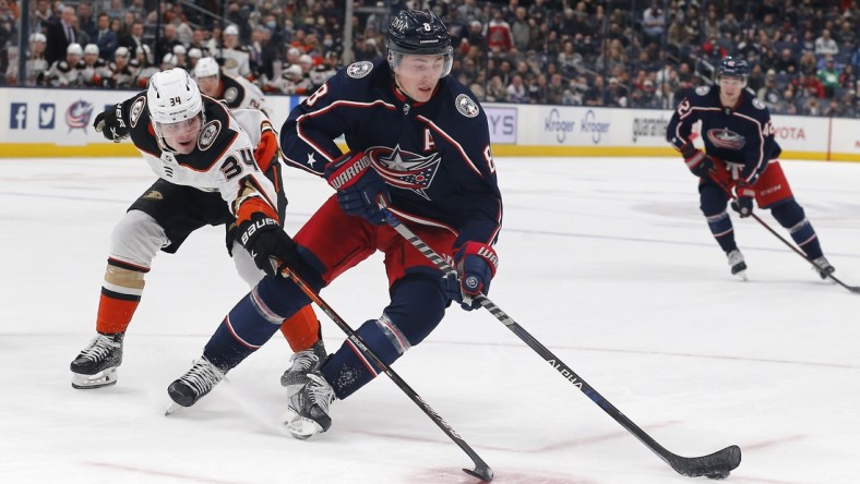 Dec 9, 2021; Columbus, Ohio, USA; Columbus Blue Jackets defenseman Zach Werenski (8) skates away from the check of Anaheim Ducks defenseman Jamie Drysdale (34) during overtime at Nationwide Arena. Mandatory Credit: Russell LaBounty-USA TODAY Sports