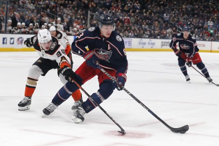 Dec 9, 2021; Columbus, Ohio, USA; Columbus Blue Jackets defenseman Zach Werenski (8) skates away from the check of Anaheim Ducks defenseman Jamie Drysdale (34) during overtime at Nationwide Arena. Mandatory Credit: Russell LaBounty-USA TODAY Sports