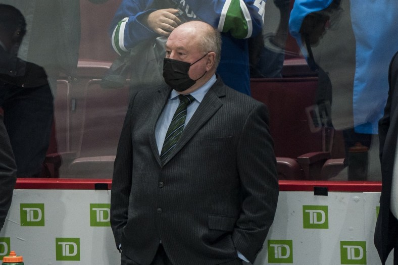 Dec 14, 2021; Vancouver, British Columbia, CAN;  Vancouver Canucks head coach Bruce Boudreau now wears a covid protective mask on the bench during warm up prior to a game against the Columbus Blue Jackets at Rogers Arena. Mandatory Credit: Bob Frid-USA TODAY Sports